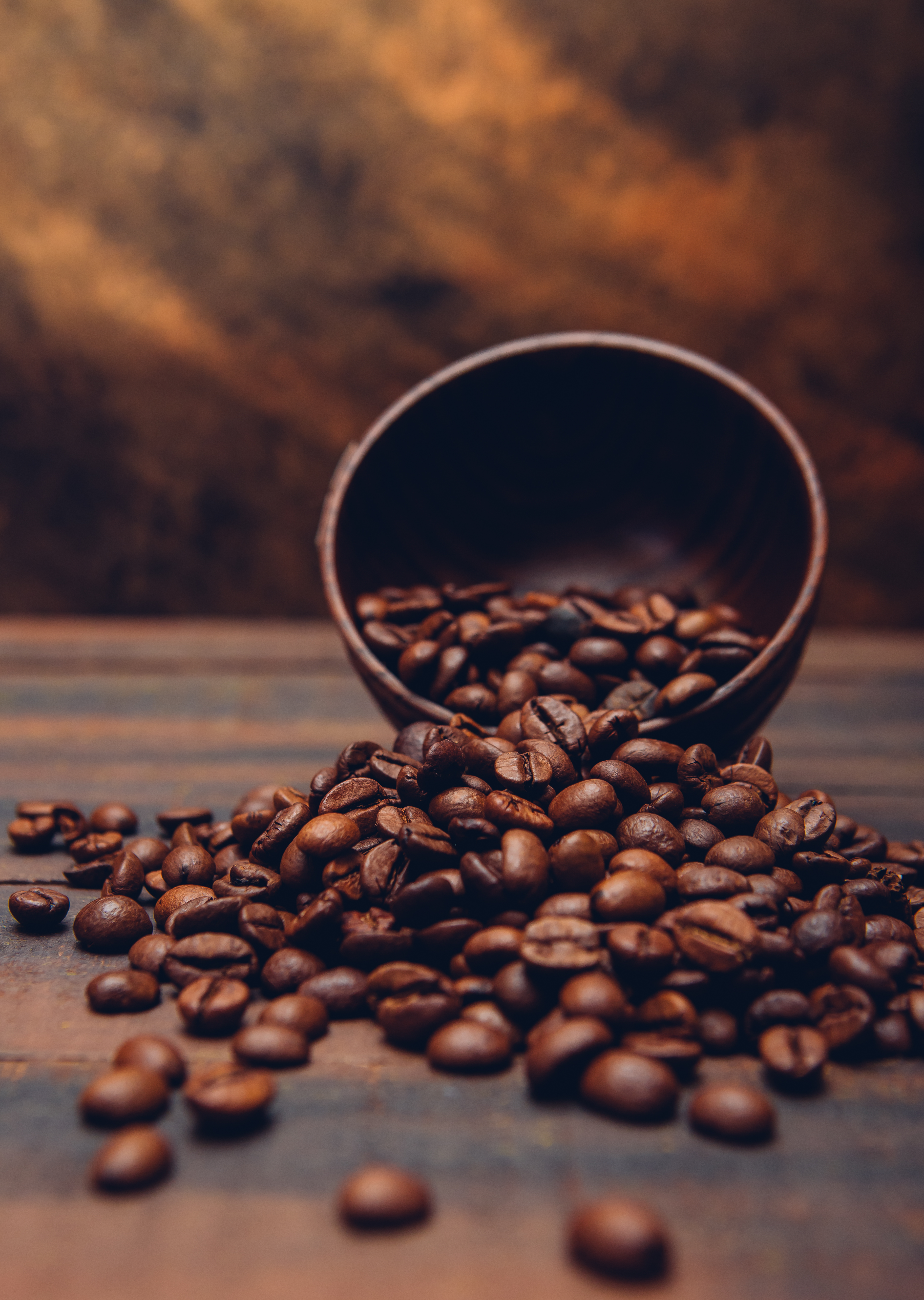Dark coffee beans in a bowl on a brown background. side view. Dark coffee beans in a bowl on a brown background. side view.